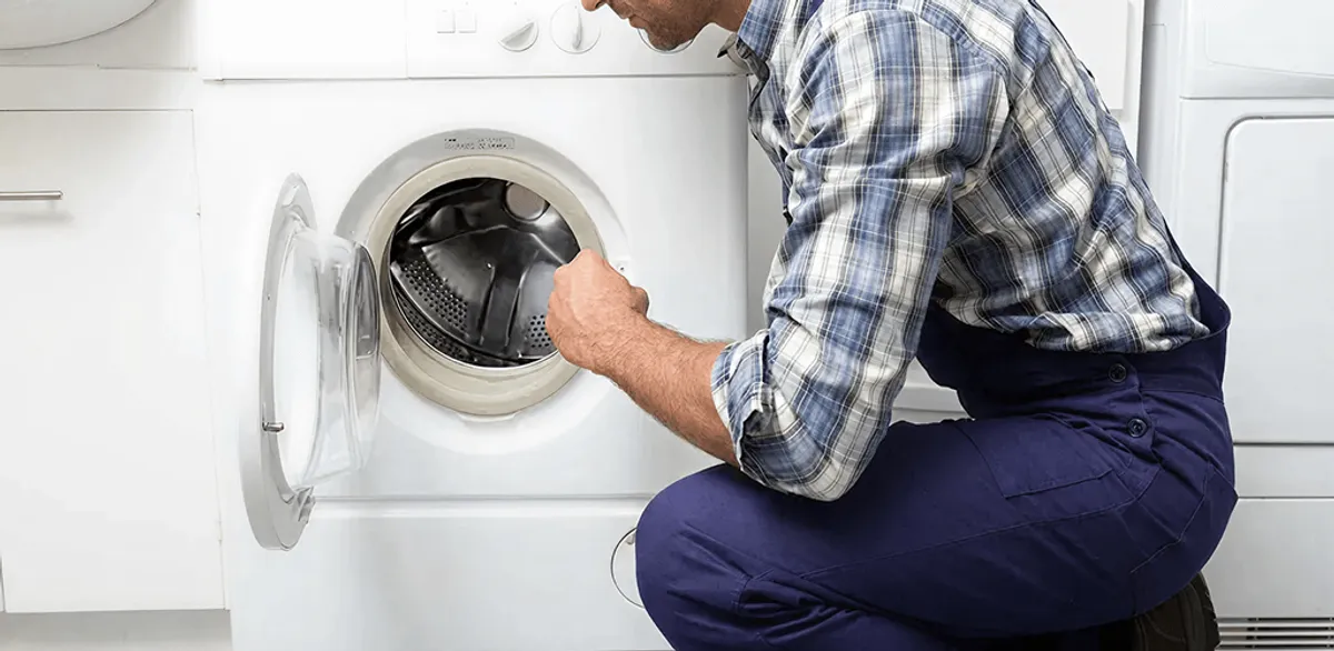 Handyman inspecting a dryer drum and internal parts for repair in Jacksonville, FL